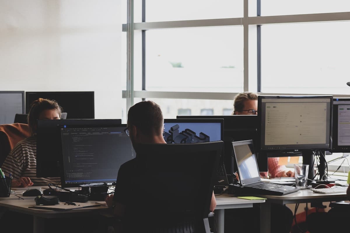 Enterprise software interface displayed across office workstations